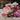 Bouquet of pink, red, and purple flowers on a wooden surface with a blurred background
